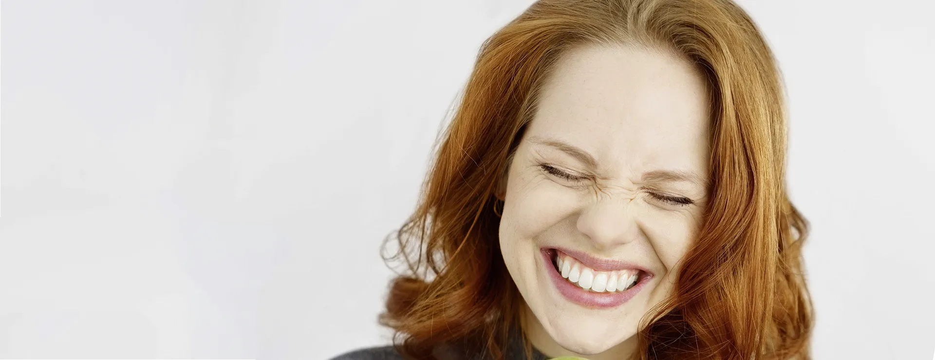 Eine lächelnde Frau, die dabei Zähne zeigt